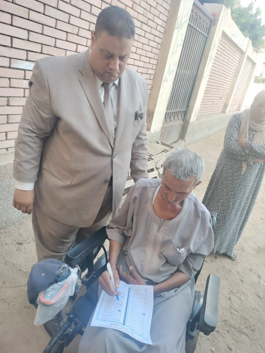 رئيس لجنة انتخابية يخرج لمساعدة مواطن ذوى احتياجات خاصة للأدلاء بصوته