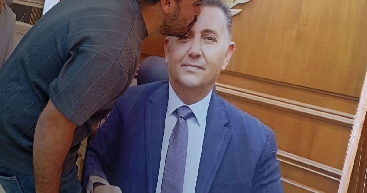 موظف بالوحدة المحلية بميت حلفا يقبل صورة المحافظ ويشيد بمجهوداته